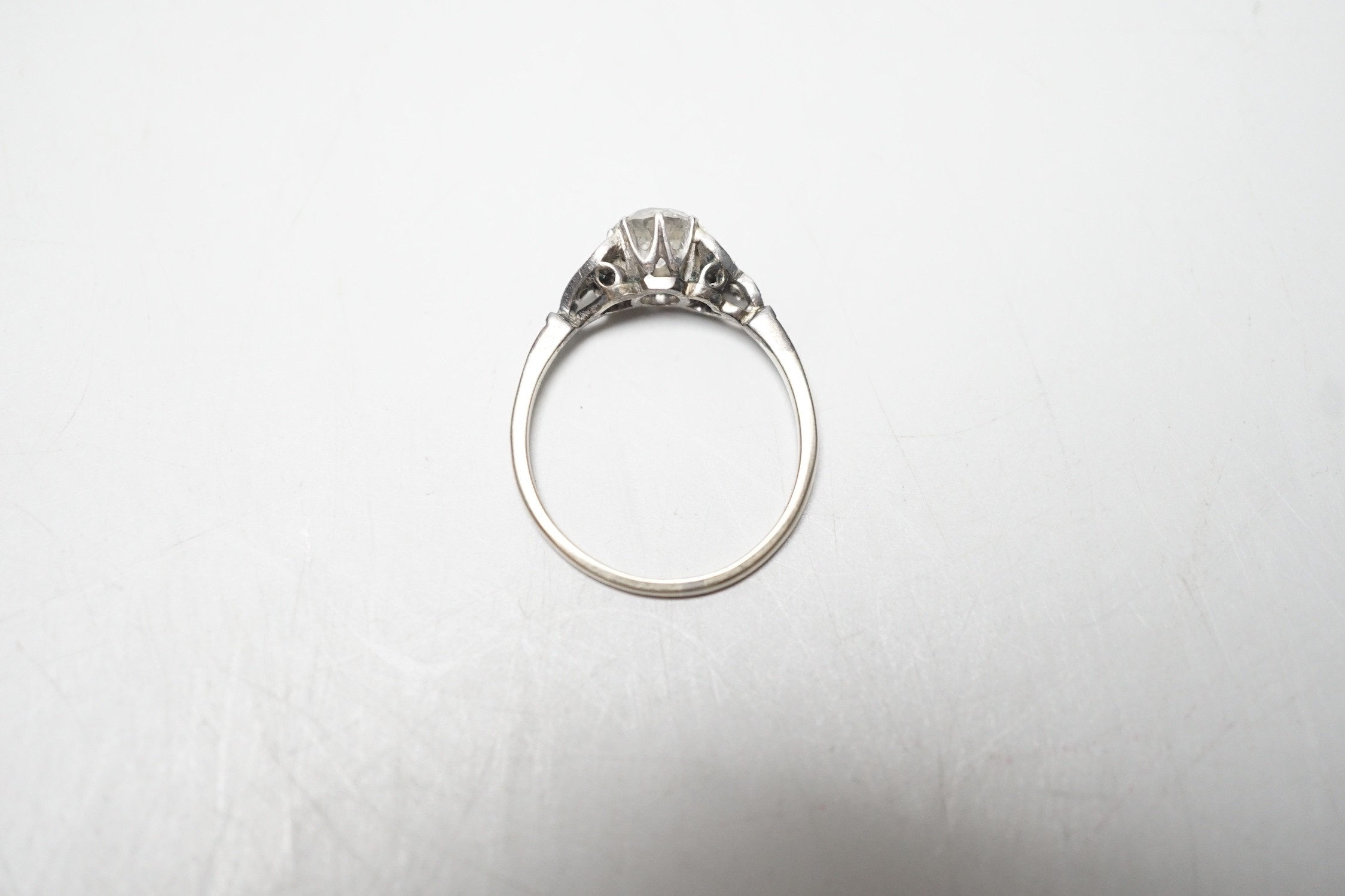 An 18ct white metal and single stone diamond ring, with diamond chip set shoulders, the stone weighing approximately 0.60ct, size M, gross weight 1.8 grams.